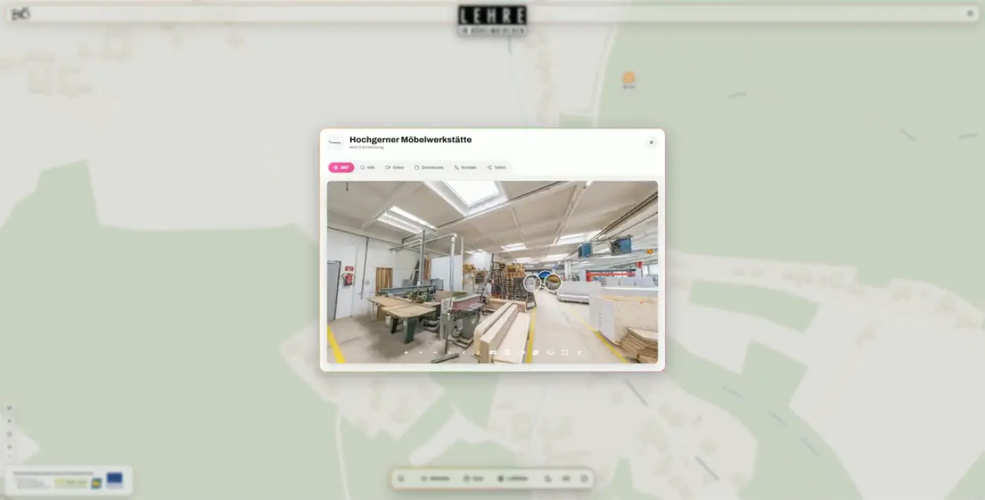 Ein Betrieb ist auf der Ortskarte geöffnet; im Fenster läuft der 360°-Rundgang durch die Möbelwerkstätte